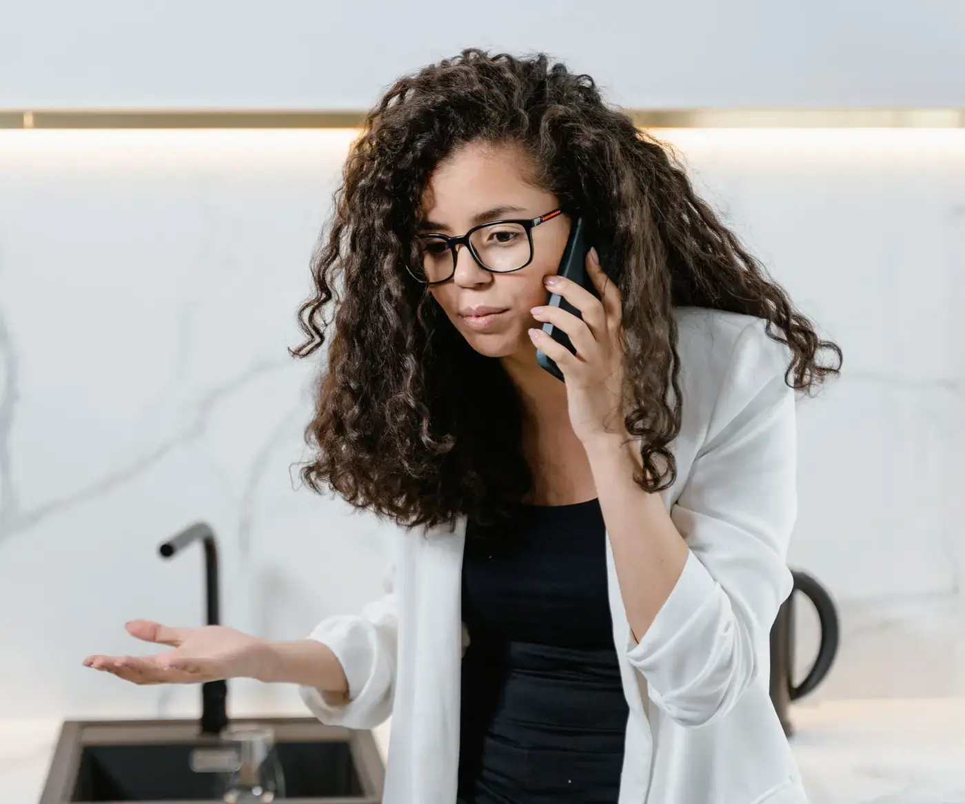 Homeowner in her kitchen on the phone, explaining a problem